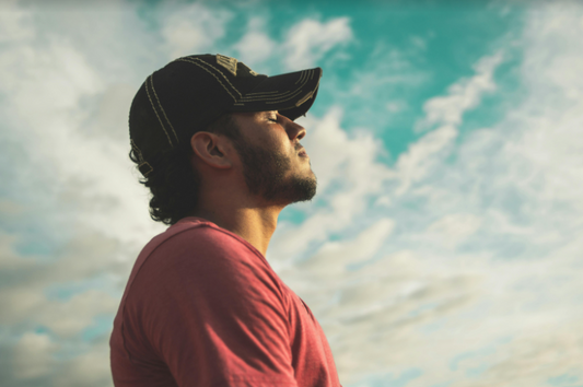 Man breathing deeply under a deep blue sky