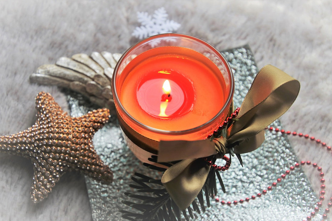 A bright red candle with a beach setting 