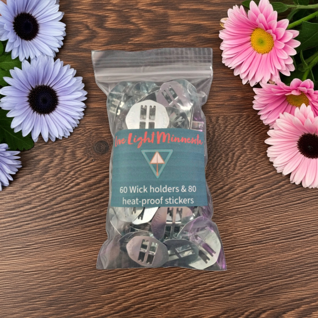 Packaged product: 60 wick holders & 80 heat-proof stickers with 'Love Light Minnesota' branding on a wooden surface with flowers.