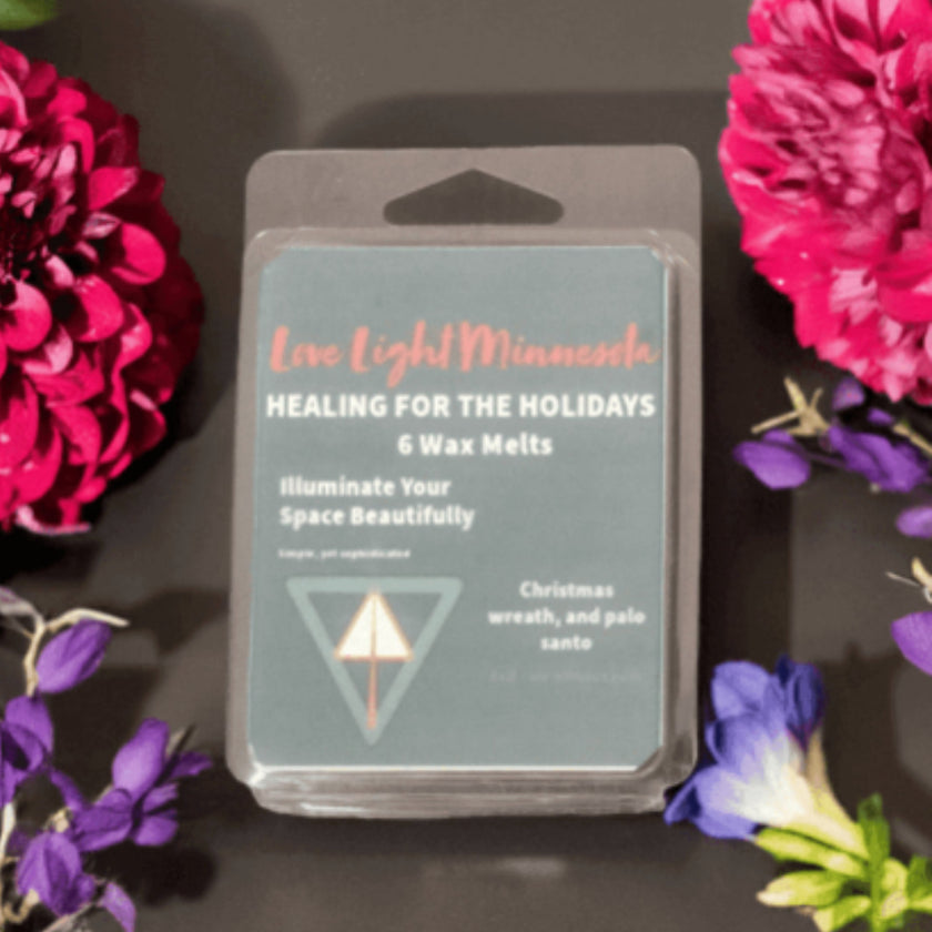 Pack of wax melts with floral decorations on a dark surface