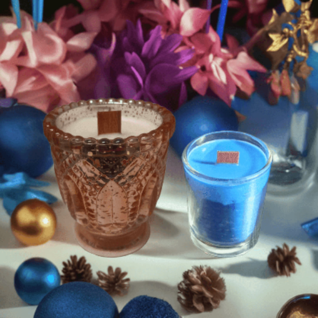 Decorative candles in glass holders with flowers and ornaments on a white surface