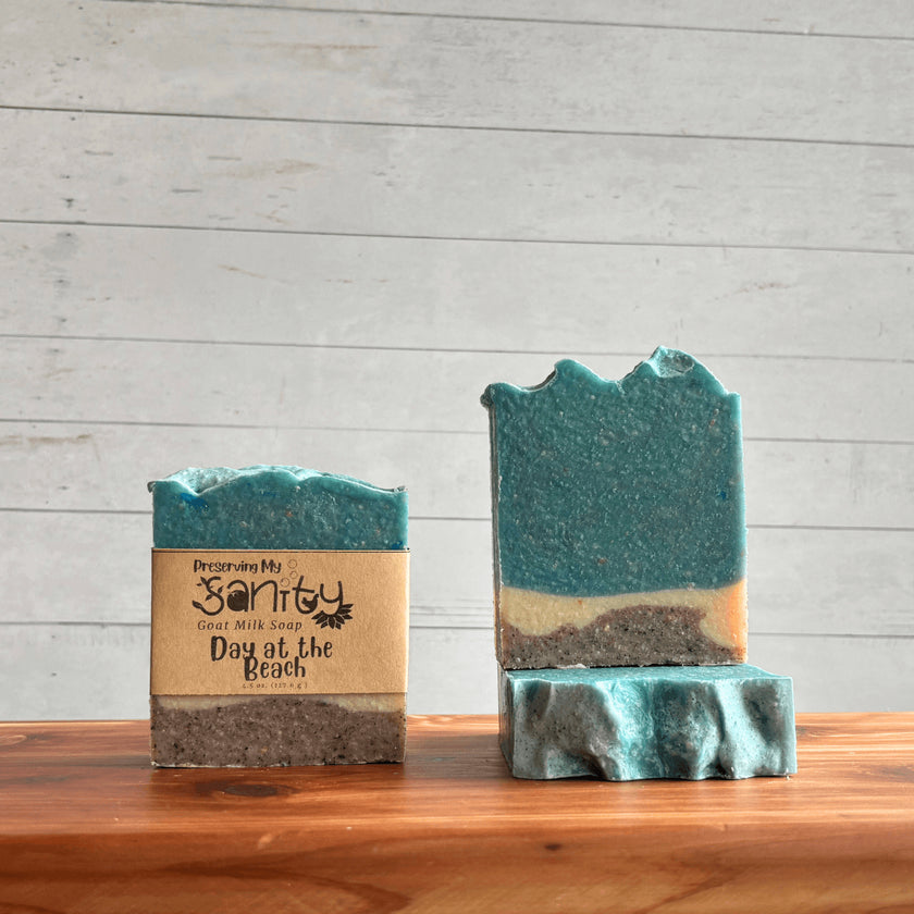 Two bars of soap called Day at the Beach with a wooden background