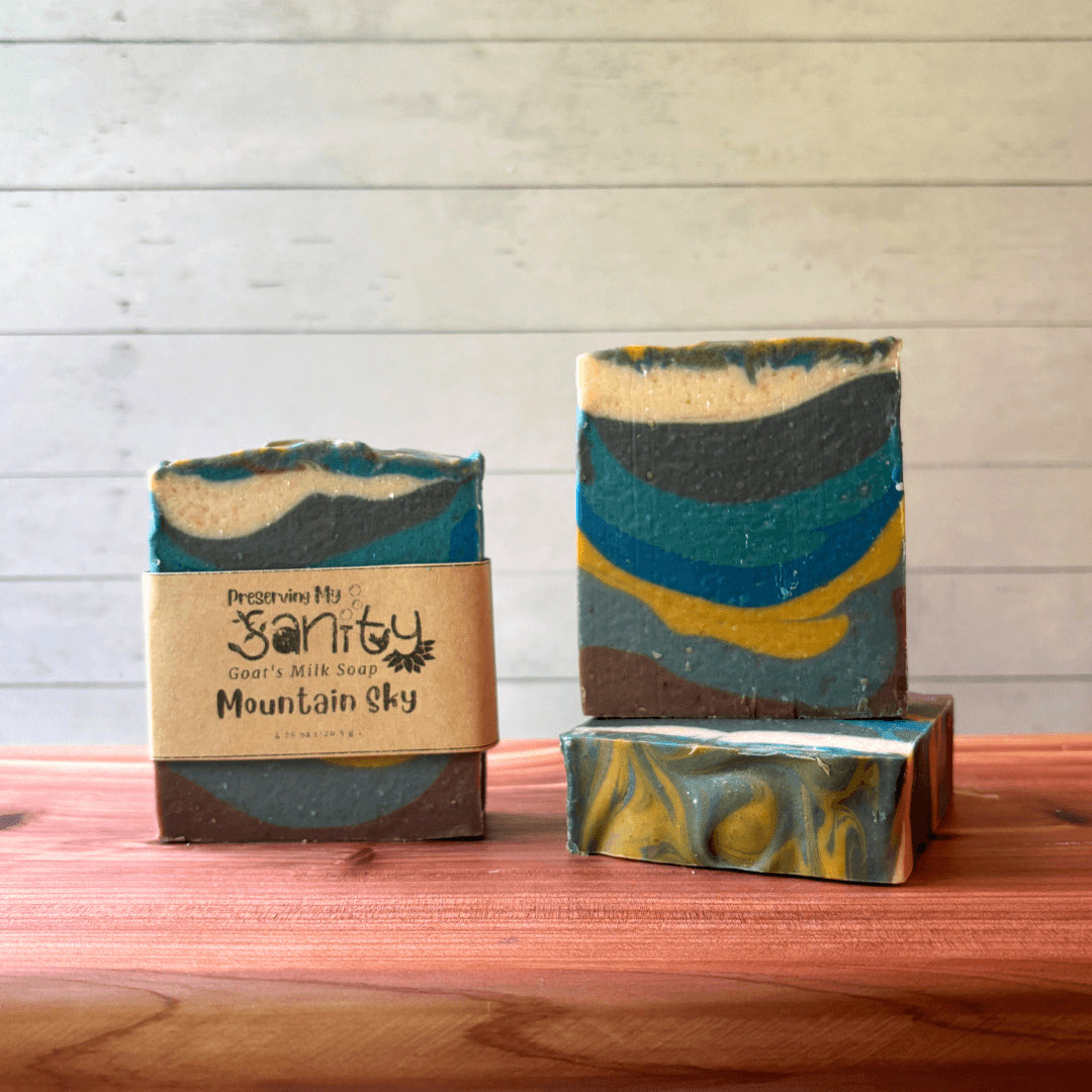 Three bars of soap called Mountain Sky with a 'Preserving My Sanity' label on a wooden surface.